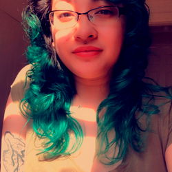 Miss Lotus, a woman with blue hair, showcasing her natural beauty.