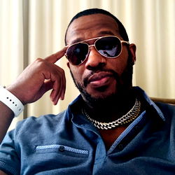 Man in Sunglasses with Crop Top and Necklace, Holding His Head
