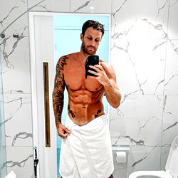 Fitness Model Showcasing Physique in Hotel Bathroom