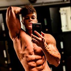 Fitness Model Andrei Showcasing Abs in Gym