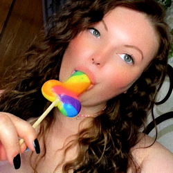 A person enjoying a rainbow lollipop