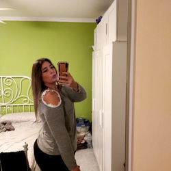 Aniwan in a Grey Sweater, Standing in a Bedroom