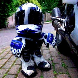A Cute Hades Statue of a Young Racer in Racing Gear and Safety Helmet