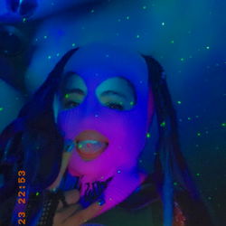 DJ in colorful outfit with sparkly background