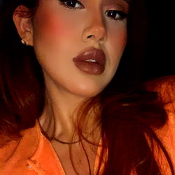 Stylish Woman in Orange Outfit with Dramatic Makeup and Accessories
