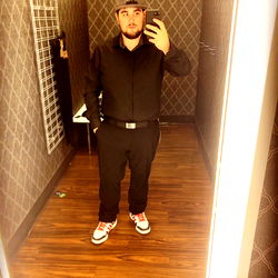 A Man Taking a Mirror Selfie in a Store Dressing Room