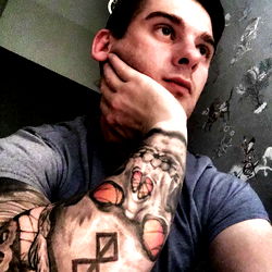 Cool Tattooed Man Resting Arm on Wall