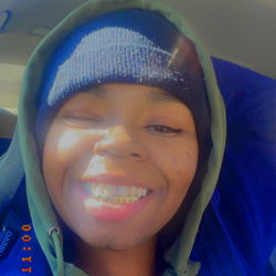 A person posing in a vehicle