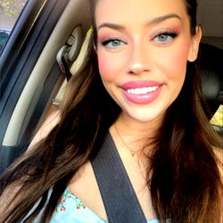 Smiling woman posing with the door open in her car