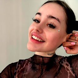 Eva, the stunning OnlyFans model with a radiant smile and tattoos