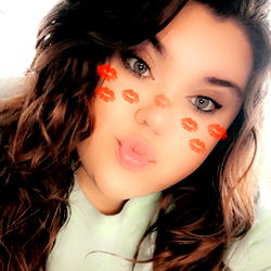 Katlynn, a social media influencer with long hair and captivating eyes, posing for a selfie in an outdoor setting.