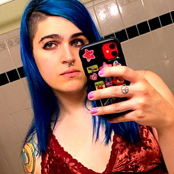 Ember, a Model Showcasing Her Tattoos and Piercing in the Bathroom