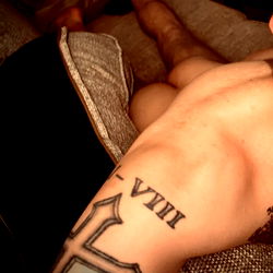 Shirtless Man with Tattoos Relaxing on Couch