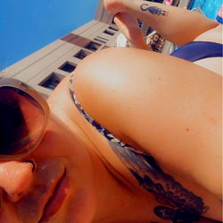 Swimsuit model posing poolside with tattoos