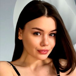 Vivi, a young woman with long hair and makeup, poses for OnlyFans