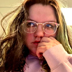 A person in glasses and a pink shirt