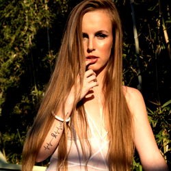 Blonde, Tattooed Model in Lingerie Strikes a Pose