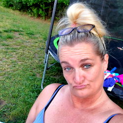 Woman in Blue Shirt Sitting Outdoors