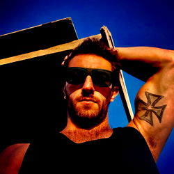 Athlete in Vintage Jeans and Sunglasses, Snowy Mountains Background