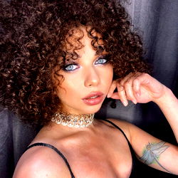 AngelAmelie, OnlyFans model, posing in a black dress with blue hair.