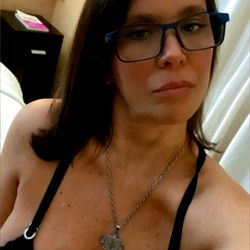 Eden, the OnlyFans model on her bed, strikingly beautiful in her black lingerie.