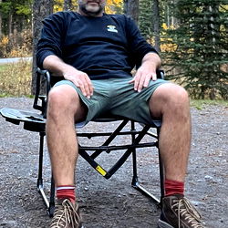 Man in Outdoor Gear Sitting on Chair