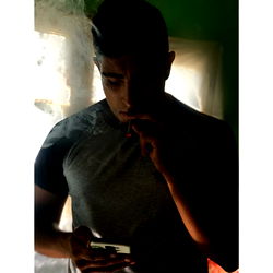 Manu, an Argentine smoker engrossed in his phone.