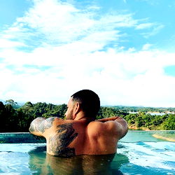 A Man Relaxing in a Swimming Pool at an Overlook