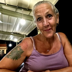 Casually Dressed Woman with Tattoos, Smiling at the Camera