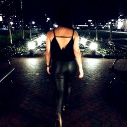 Fashionable Model Strolls Through Brick Pavement at Night