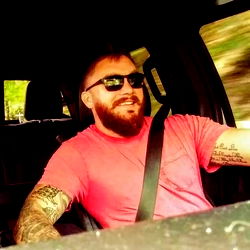 Man in sunglasses, beard, and tattoo