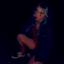 A Teenage Woman Crouching Outdoors at Night