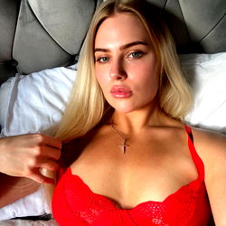 Amanda 🌸, an OnlyFans model in red lingerie lying on bed