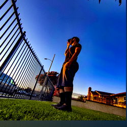 A Man on the Grass at Dusk, Engrossed in his Phone