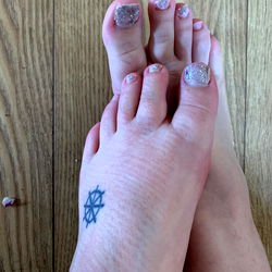 A Close-Up of Feet with Nail Art and Tattoos