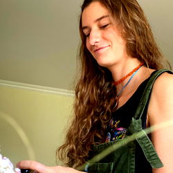 Ukrainian model Amarita Franchetti with phone in hand, standing in kitchen.
