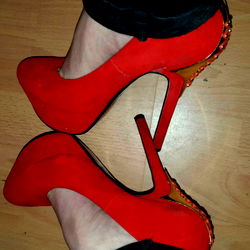 High-Heeled Shoe with Sole Detail on Wood Floor